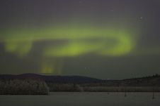 Aurora Swirl Over Distant Woods Stock Image