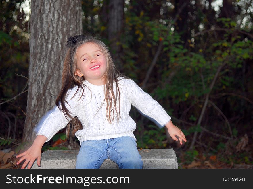 A beautiful little girl acting very silly during a photo shoot.  She has a funny face.