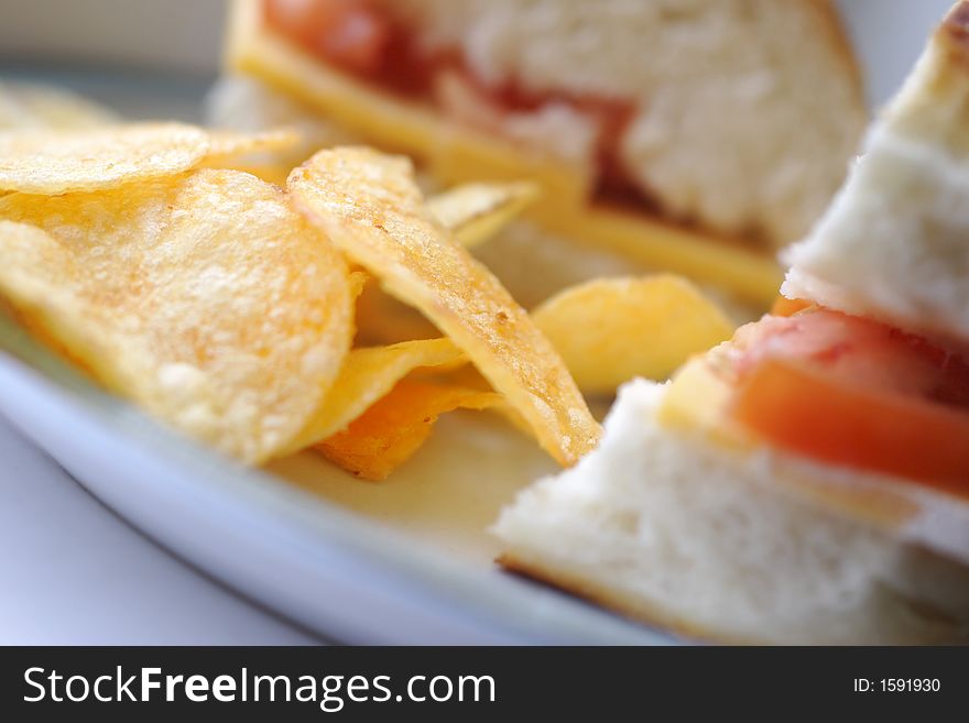 Cheese and tomato sandwich with potato chips, shallow depth of field. Cheese and tomato sandwich with potato chips, shallow depth of field