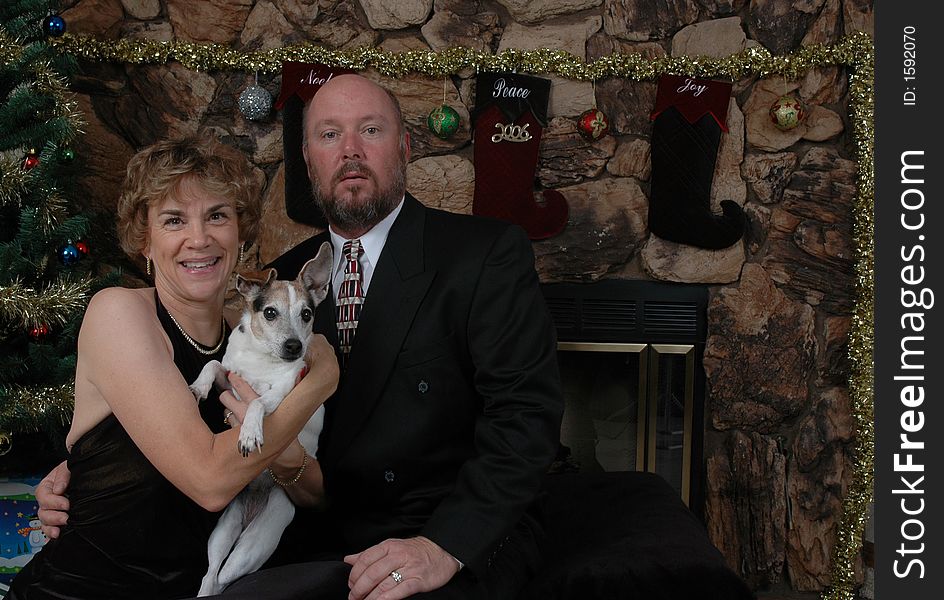 Couple with their dog in front of the Christmas tree. Couple with their dog in front of the Christmas tree