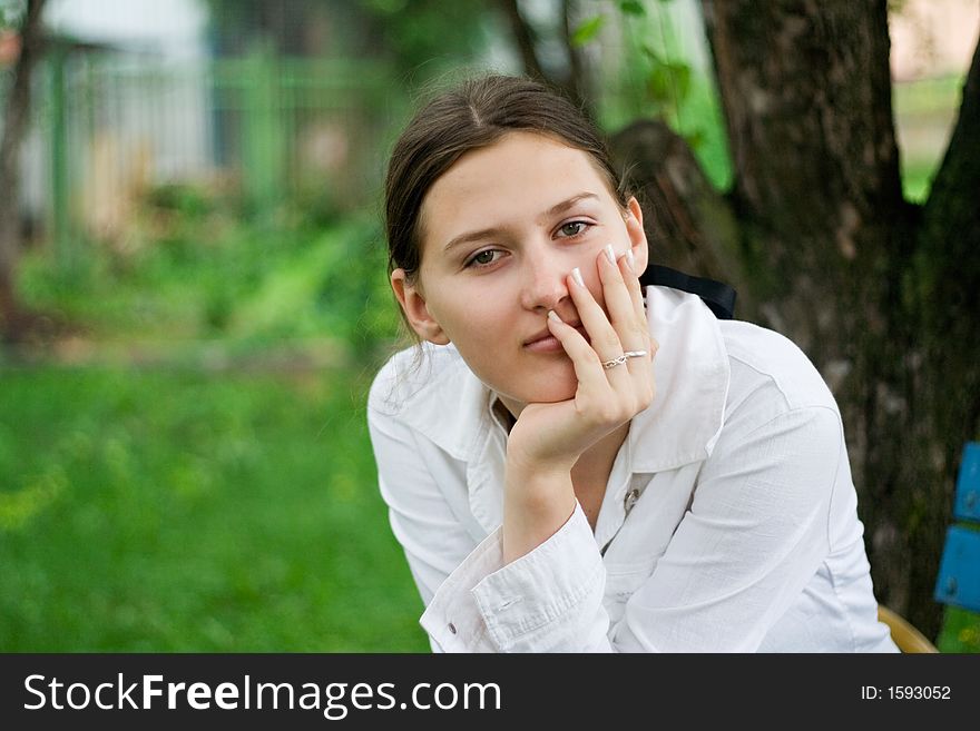 Portrait of a pretty girl sitting outside thoughtfully