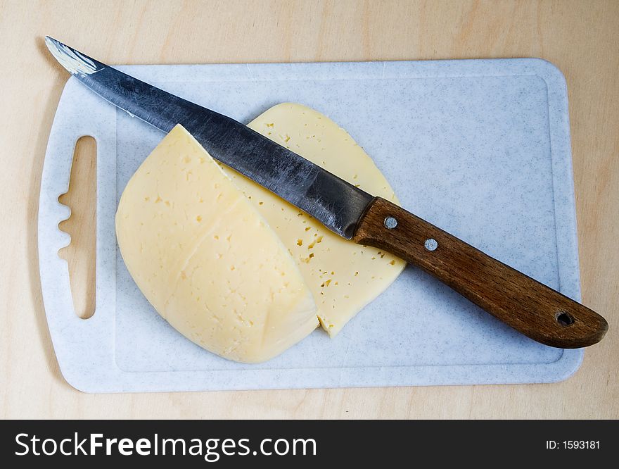 Cheese and knife on a cutting board