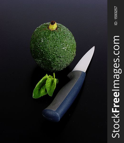 Composition whit green avocado, knife and leaves of spinach