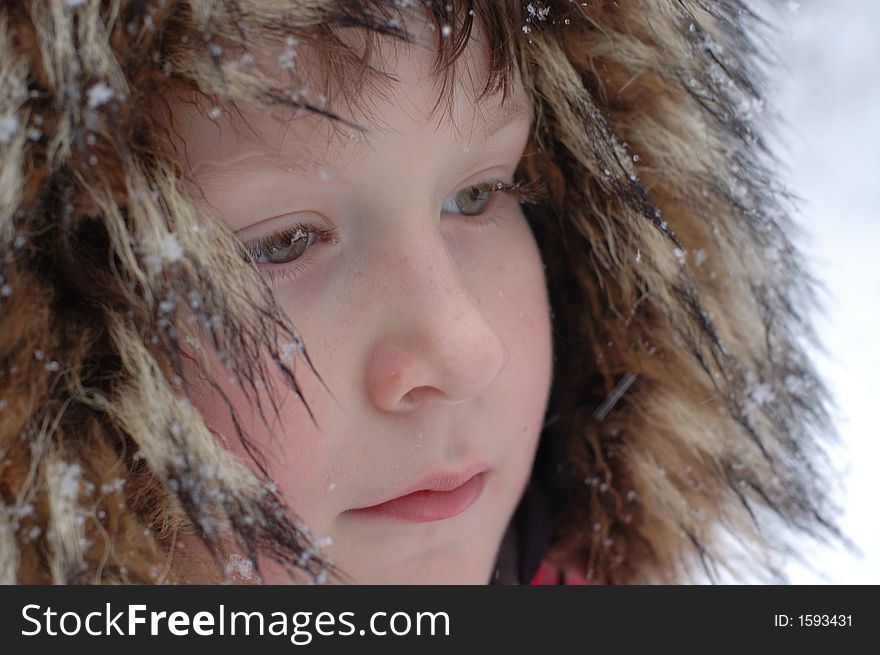 Portrait of young boy in fur hat covered with snow - side view - partial. Portrait of young boy in fur hat covered with snow - side view - partial