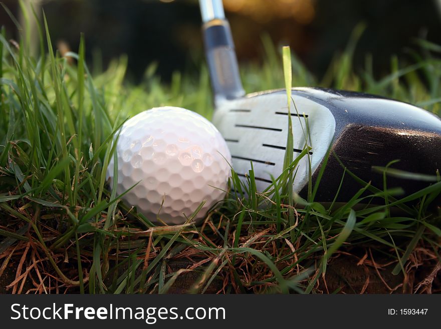 Driver about to hit a golf ball from the rough - low angle shot. Driver about to hit a golf ball from the rough - low angle shot