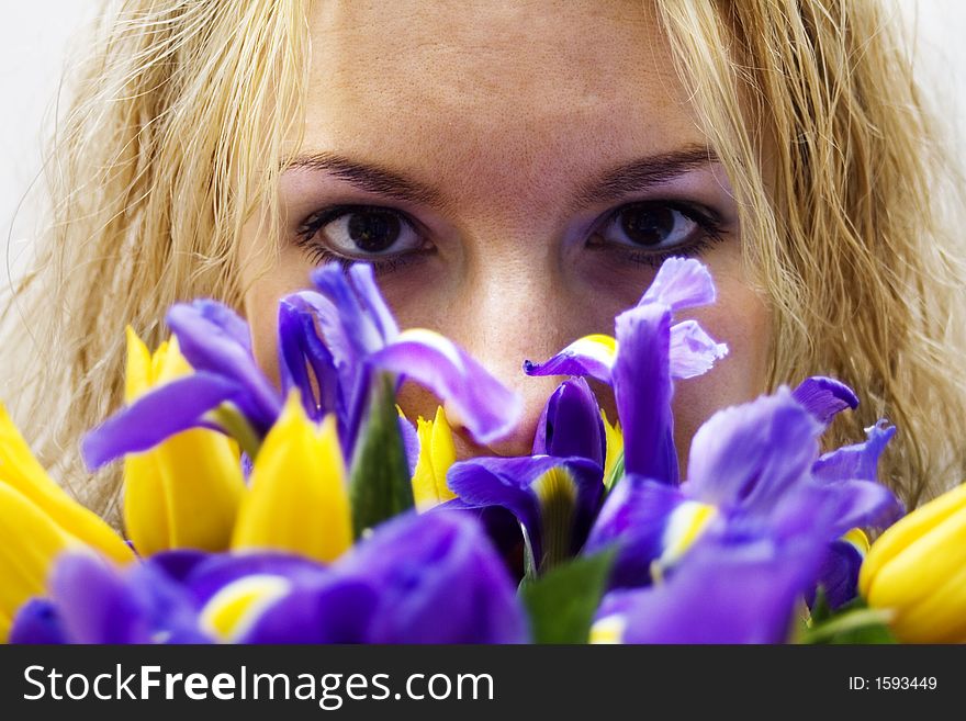 Blond girl smelling beautiful flowers. Blond girl smelling beautiful flowers