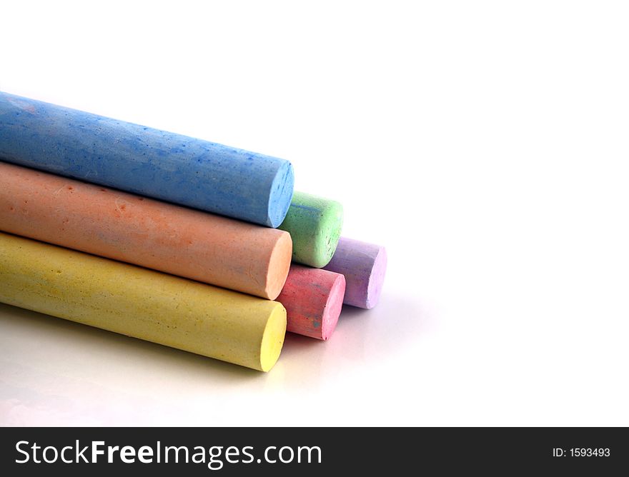Pyramid of brightly colored chalks on a white reflective background. Pyramid of brightly colored chalks on a white reflective background