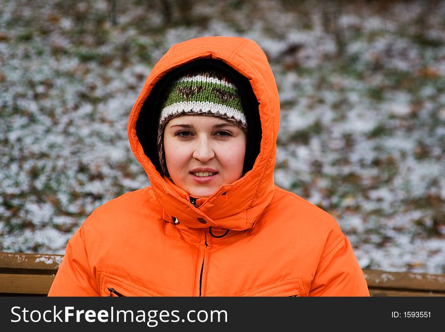 Young woman sitting on bench in a winter park. Young woman sitting on bench in a winter park