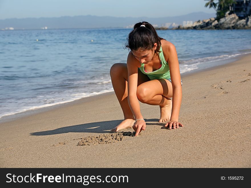 Girl drawing on the sand at the beach. Girl drawing on the sand at the beach