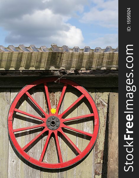 An old red wheel and a flower