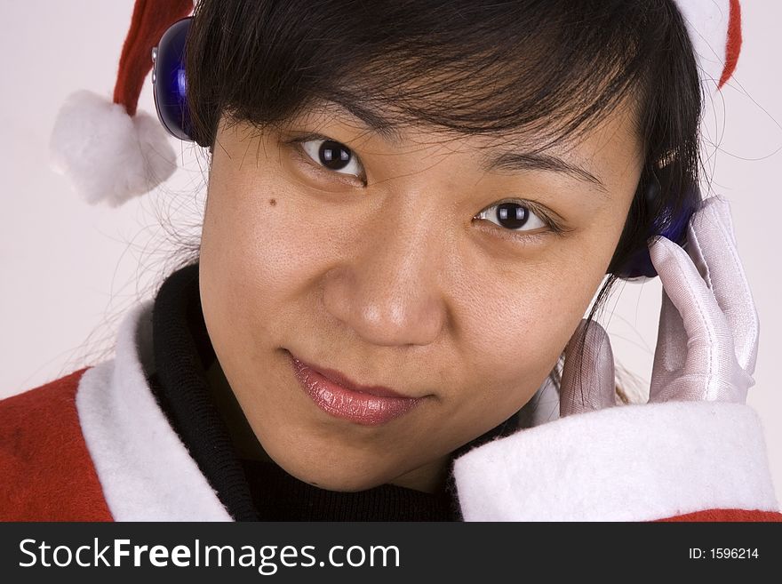 Asian Female Santa Claus listening mp3 music. Asian Female Santa Claus listening mp3 music.