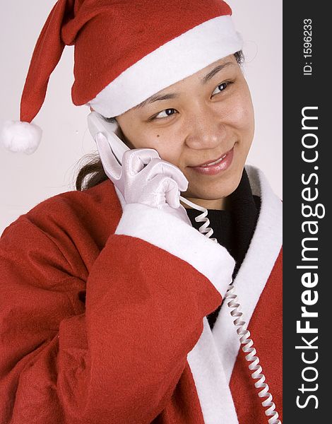 Asian female santa claus making a phone call. Asian female santa claus making a phone call.
