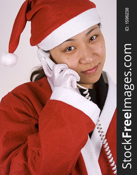 Asian female santa claus making a phone call. Asian female santa claus making a phone call.