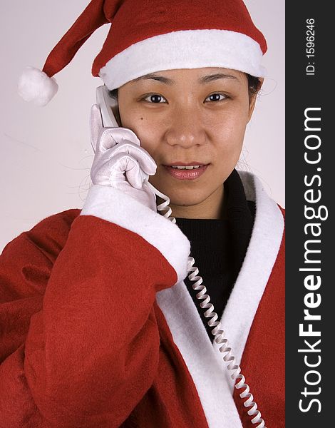 Asian female santa claus making a phone call. Asian female santa claus making a phone call.