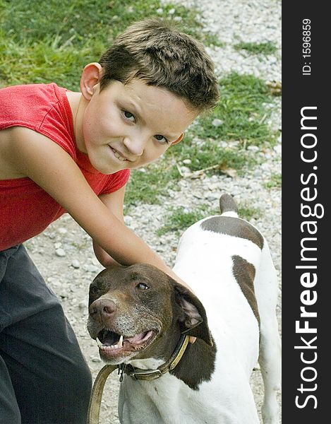 A boy reaches down to pet a dog. A boy reaches down to pet a dog.