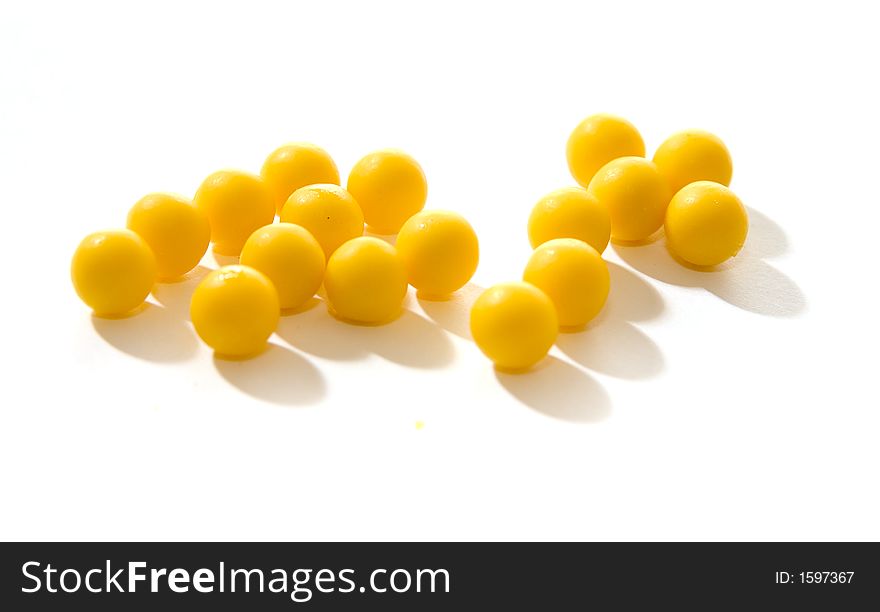 Yellow round pills of multivitamins on a white background