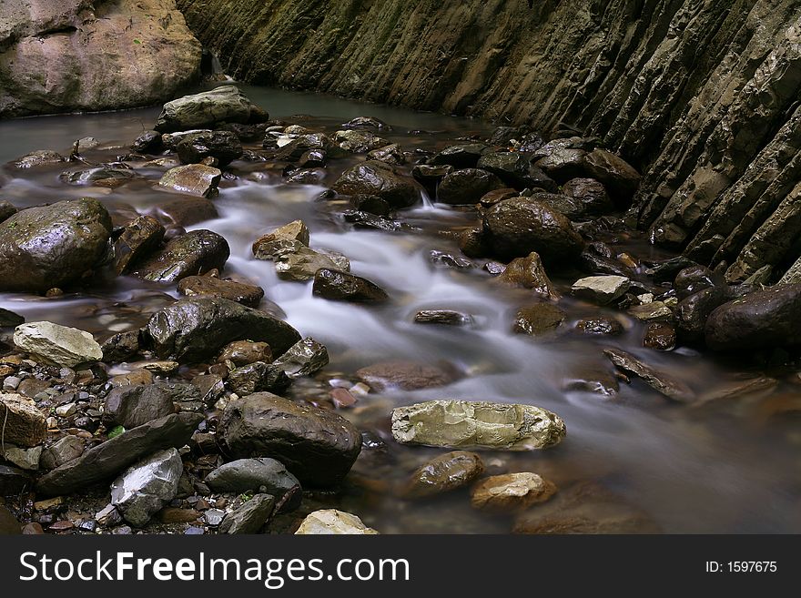 The stream runs between stones and rocks. The stream runs between stones and rocks