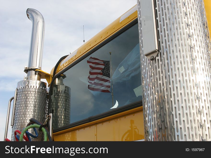 Reflection of american flag in rear window of truck with chrome smokestacks. Reflection of american flag in rear window of truck with chrome smokestacks