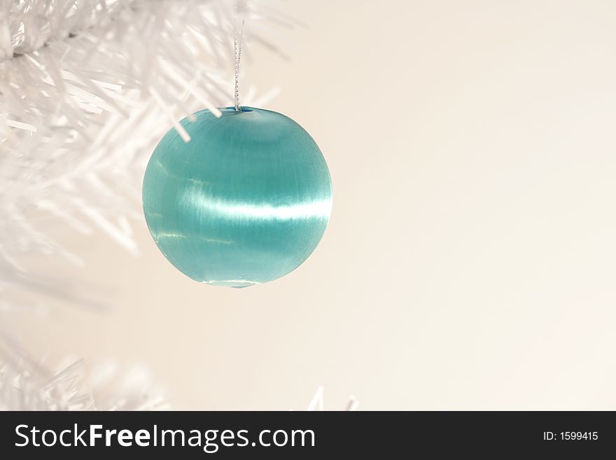 Aqua blue Christmas ornament hanging from branch of modern white artificial tree. Aqua blue Christmas ornament hanging from branch of modern white artificial tree