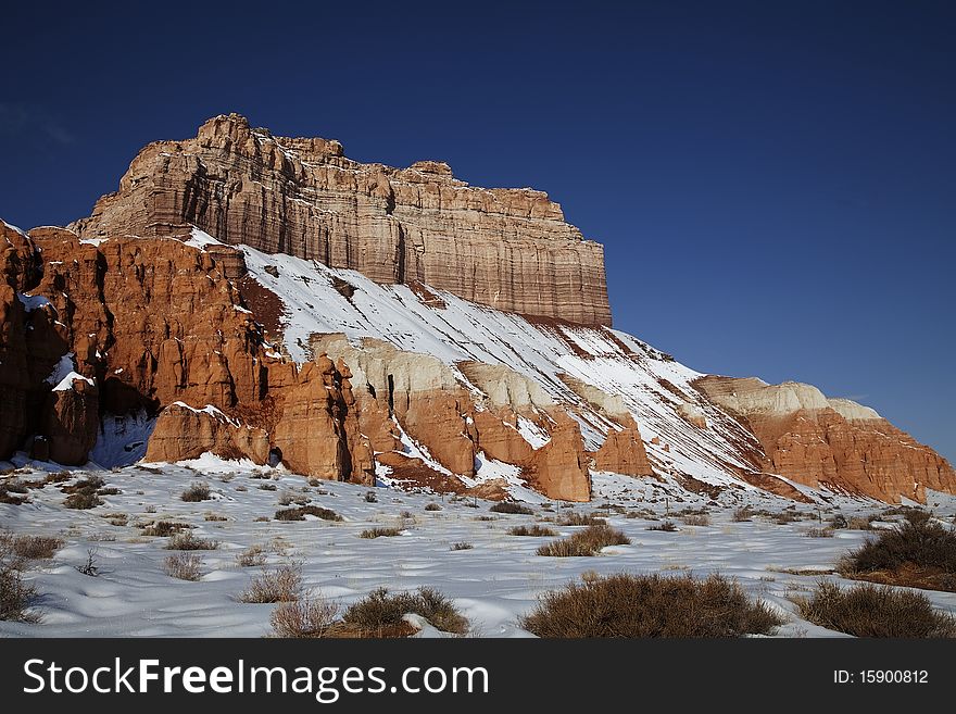 View of the red rock formations in Goblin Valley with blue sky�s and clouds and snow on the ground