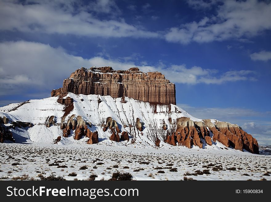 View of the red rock formations in Goblin Valley with blue sky�s and clouds and snow on the ground