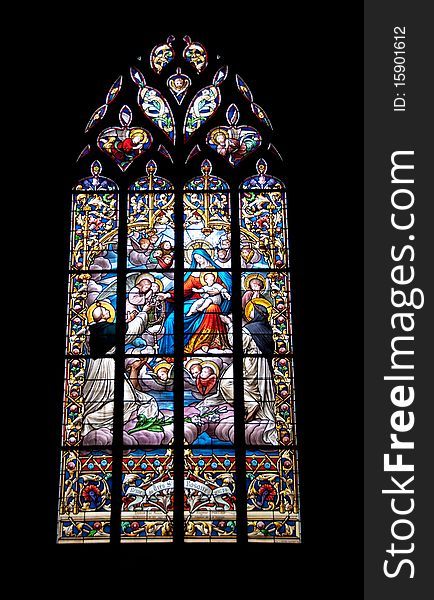 Stained glass window in a church showing a religious scene. St Dominic and St Rita receiving the rosary beads from the Blessed Virgin. Stained glass window in a church showing a religious scene. St Dominic and St Rita receiving the rosary beads from the Blessed Virgin.