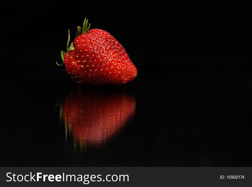 Red strawberry on black background
