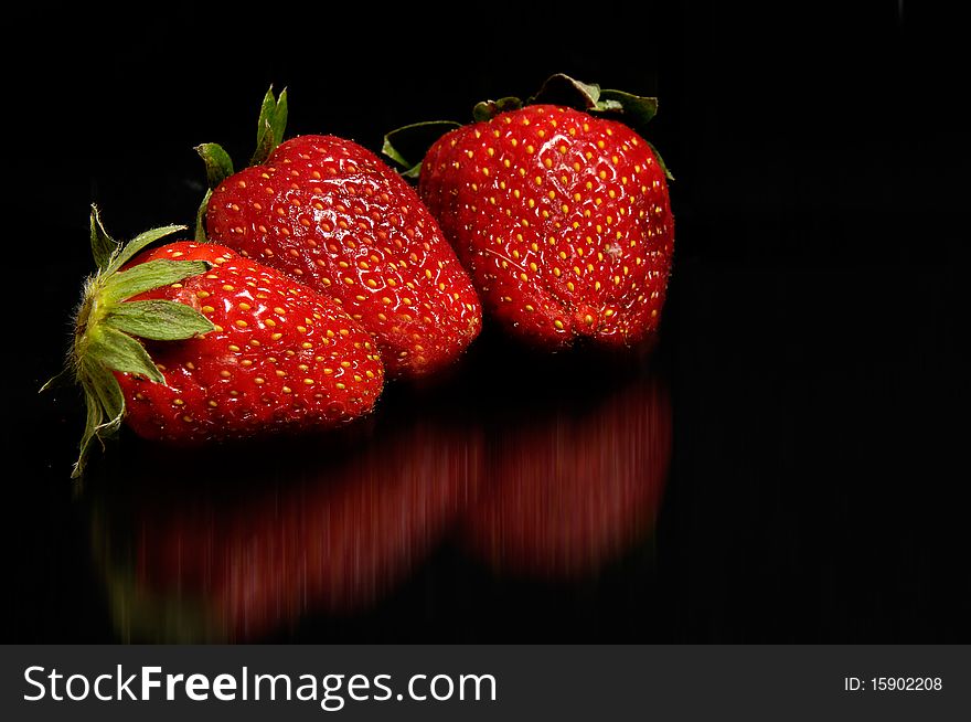 Three red strawberries on black background. Three red strawberries on black background
