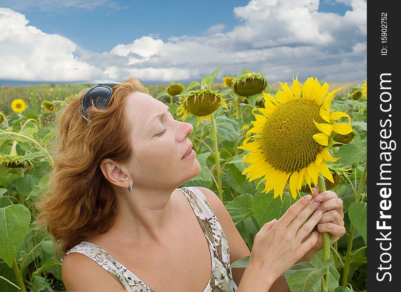 The beautiful woman in the field of sunflowers