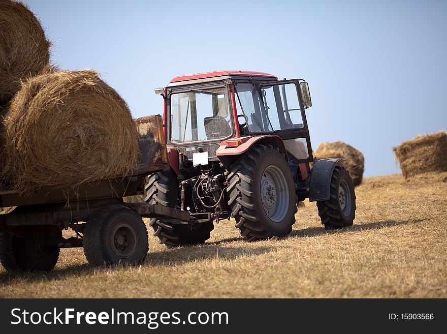 Tractor carries a haystack on a summer evening
