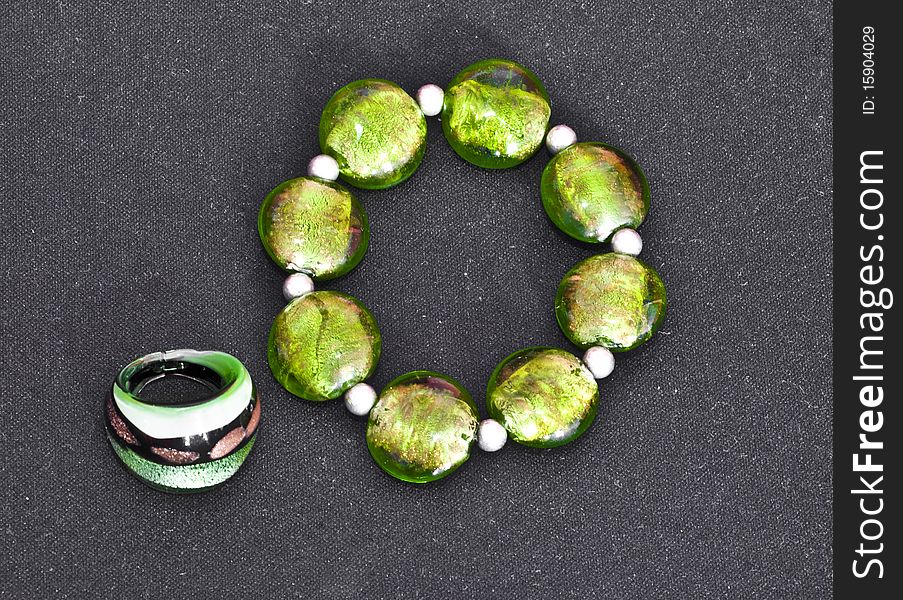 Green stones bracelet and ring isolated on black