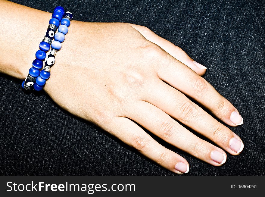 Turkish handmade jewellery - proroc eye, blue bracelets on woman hand, isolated on black
