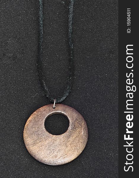 Brown wooden necklace on black background