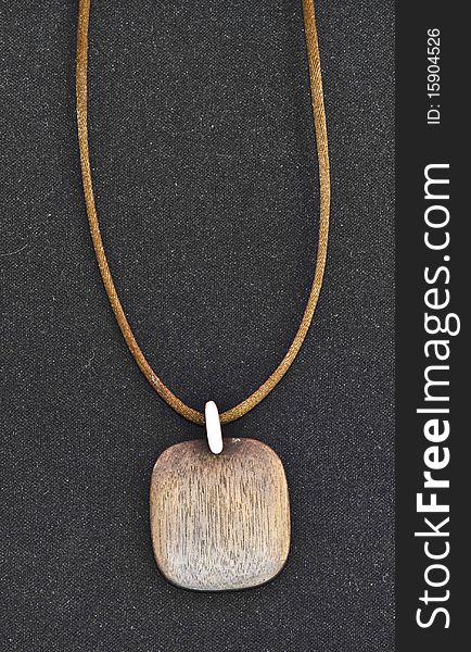 Brown wooden necklace on black background