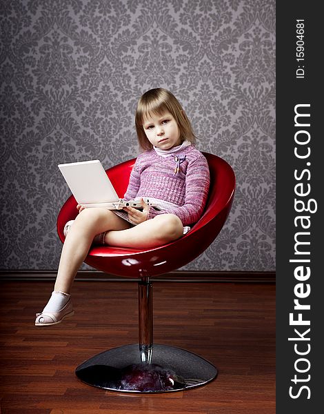 Girl sitting in a chair with a laptop