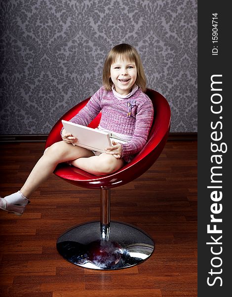 Image of girl sitting in a chair with a laptop