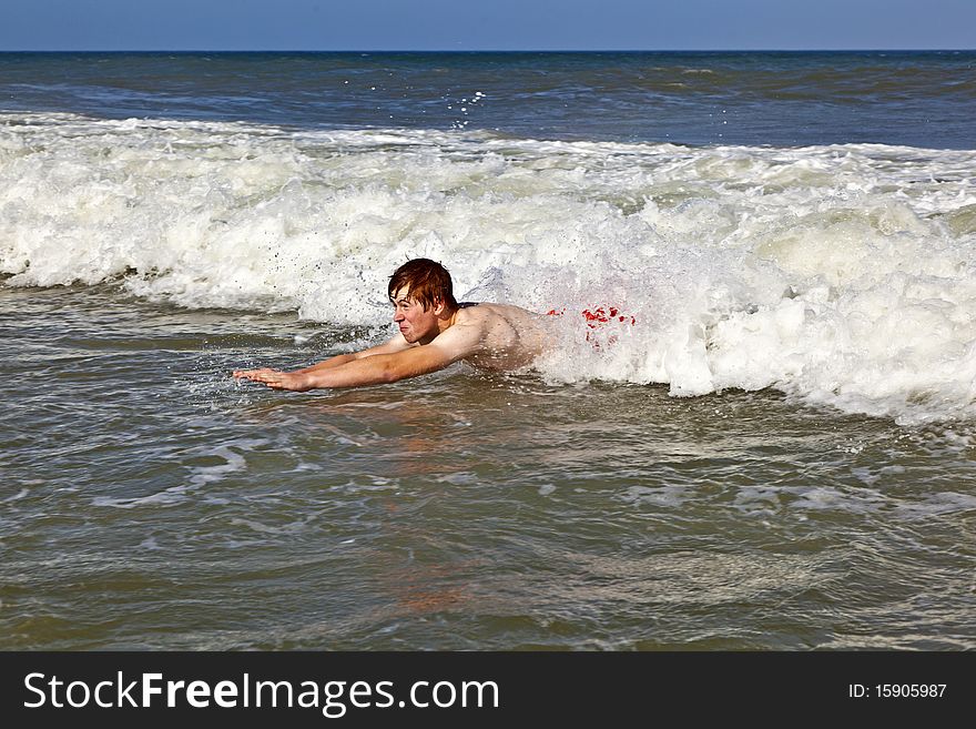 Young boy is body surfing in the waves