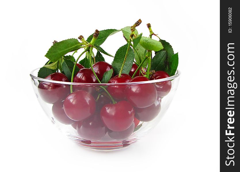 Cherries in glass bowl isolated on white background