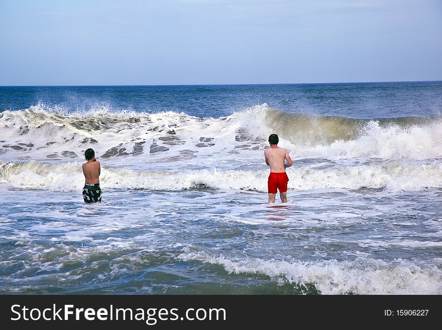 Brothers have fun in the waves of the ocean. Brothers have fun in the waves of the ocean