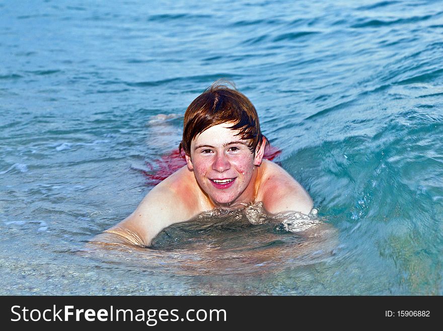 Boy lying at the beach enjoys the surf of the sea