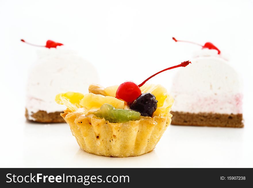 An image of cakes with cherry on top. On white background.