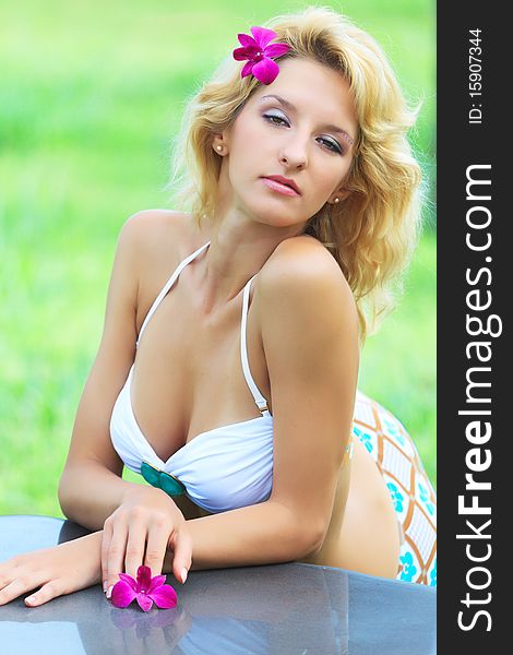 Beautiful woman in tropical garden leaning on the table. Beautiful woman in tropical garden leaning on the table