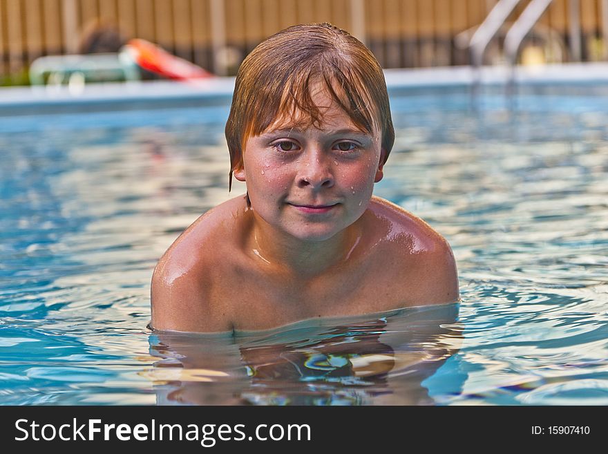 Boy enjoys swimming in an outdoor pool. Boy enjoys swimming in an outdoor pool