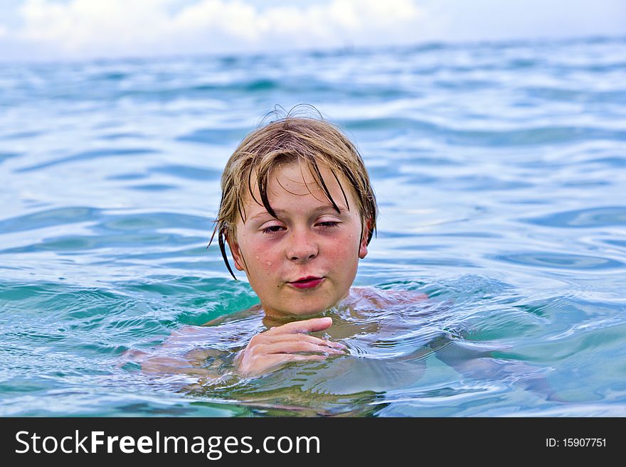 Child is swimming late afternoon in the ocean. Child is swimming late afternoon in the ocean