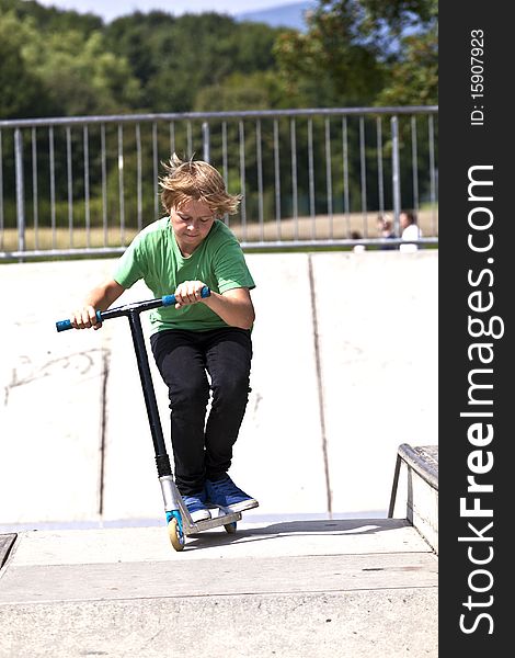 Young boy going airborne with his scooter at the skate park