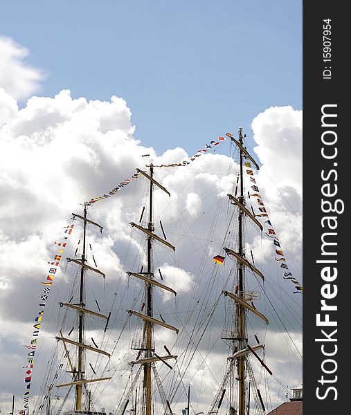 Masts of a bark and many flags with cloudy blue sky in the back. Masts of a bark and many flags with cloudy blue sky in the back