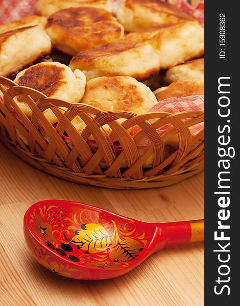Curd pancakes and decorated spoon on a wood table. Curd pancakes and decorated spoon on a wood table