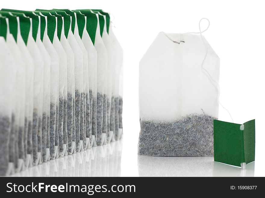 A row of teabags and one aside isolated over white.