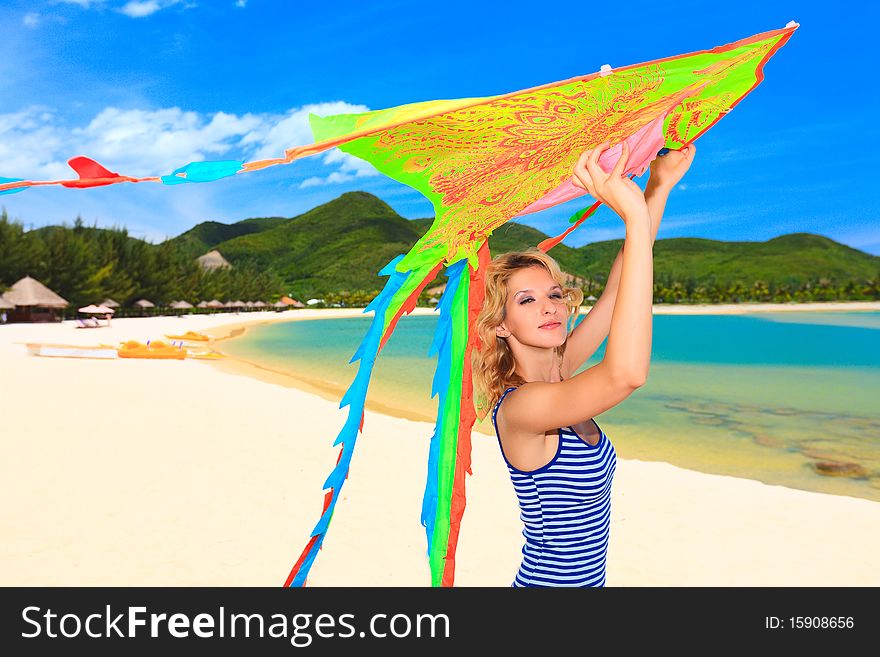 Young woman with kite on the beach