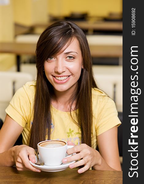 Beautiful girl with cup of coffee in restaurant